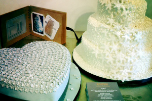 a blue heart shaped cake and white tiered wedding cake 