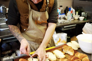 a baker cutting fresh croissants