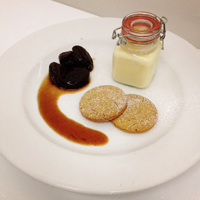 a chocolate pudding with desert bicuits and sauce 